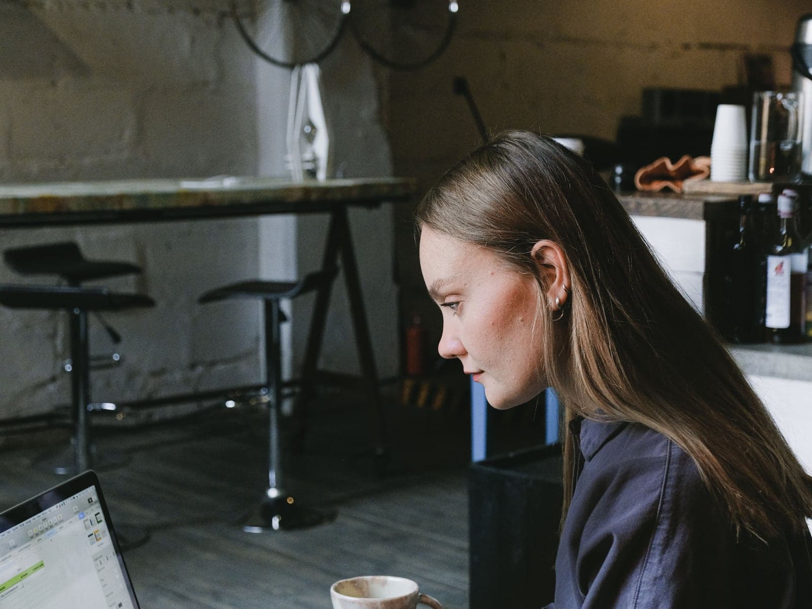 A small-business owner working with a laptop in a cafe