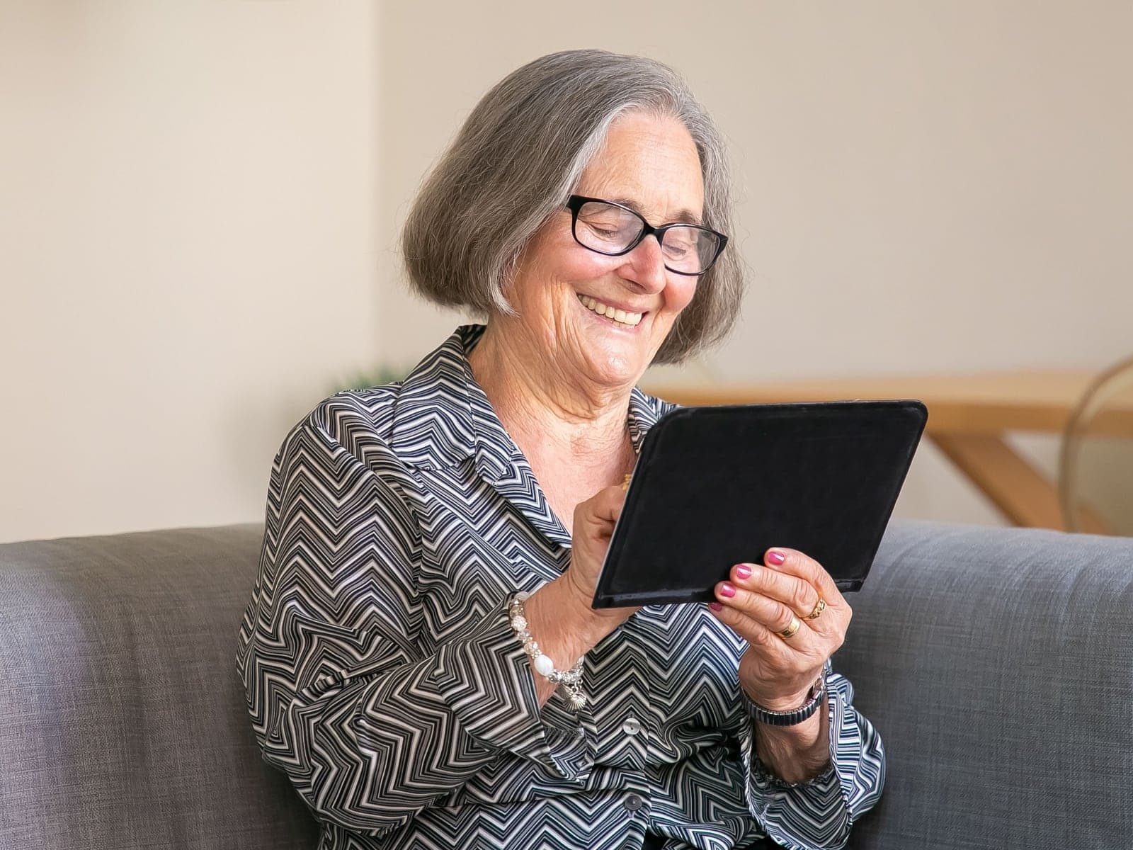 An older woman confidently using a tablet at home