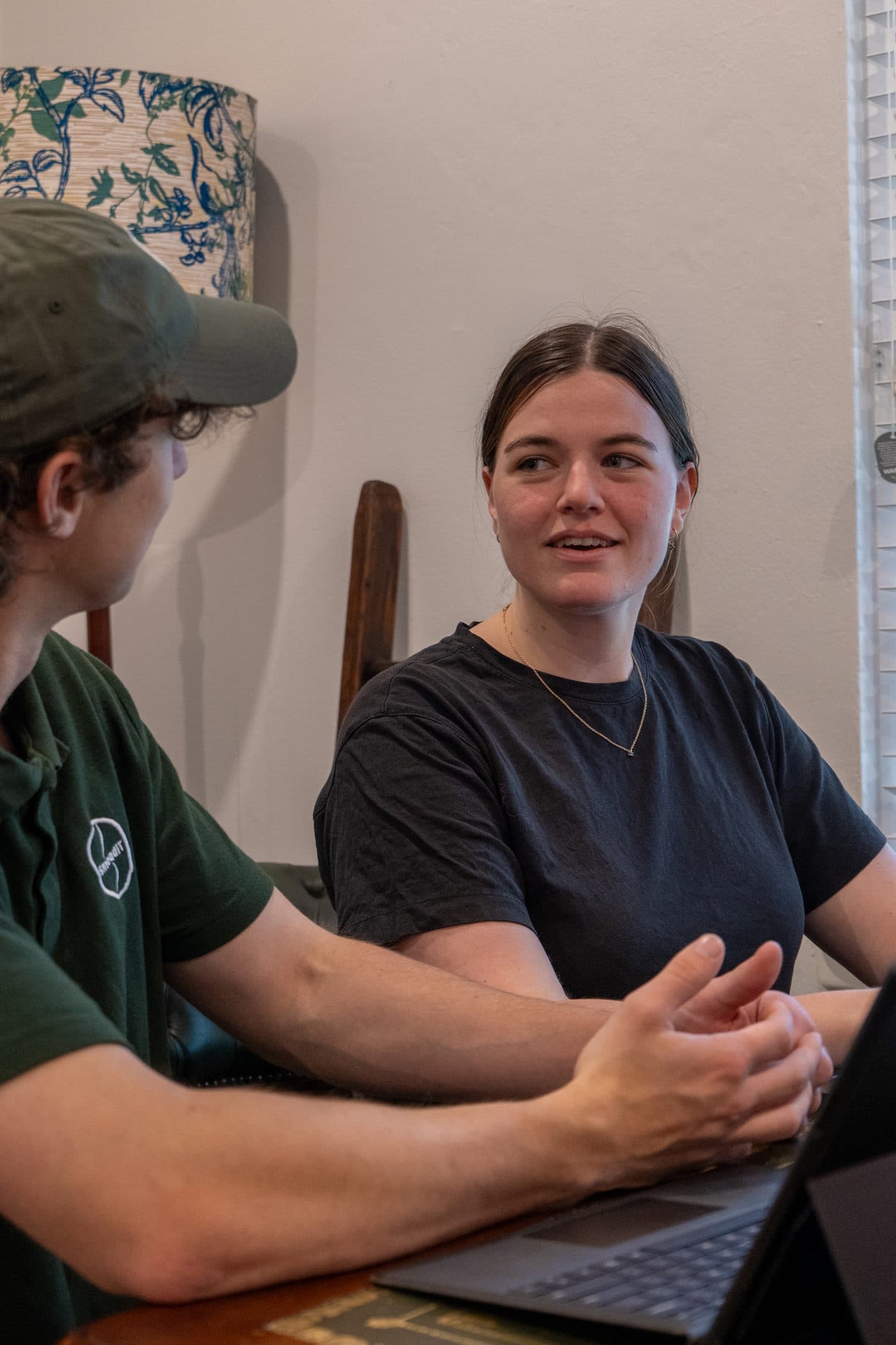 A technician and a customer talking through a laptop at the table